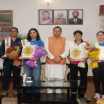 CM Dhami with women boxers Kajal Farswan, Aarti Dhariwal and Nikita Chand