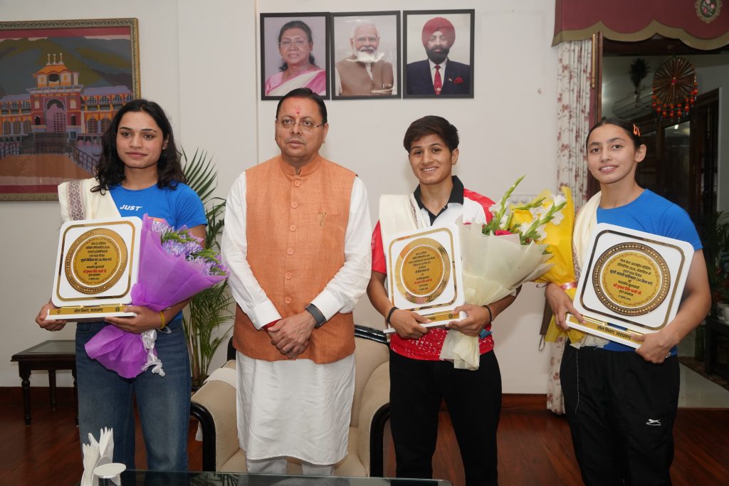CM Dhami with female boxers Kajal Farswan, Aarti Dhariwal, and Nikita Chand
